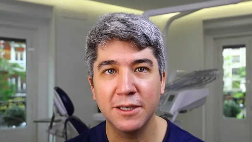 A surgeon in scrubs explaining the Khoury Technique in a dental surgery